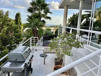 two beds in a room with a book shelf at Entire villa with pool, ocean & mountain views in Sitges