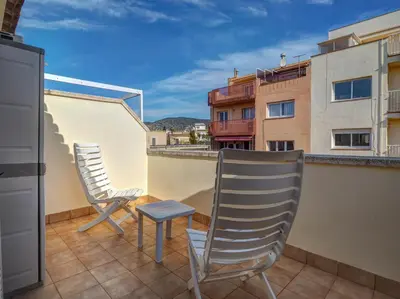 two chairs and a stool on the balcony of a building at Ribes Duplex by Hello Homes Sitges in Sitges