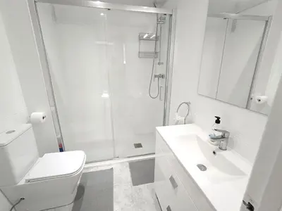 a white bathroom with a shower and a sink at CUNIT PLaYA in Cunit