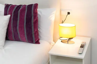 a bed with a pillow and a lamp on a table at BruStar Sagrada Familia in Barcelona