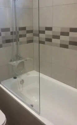a glass shower door on a tub in a bathroom at BruStar Sagrada Familia in Barcelona