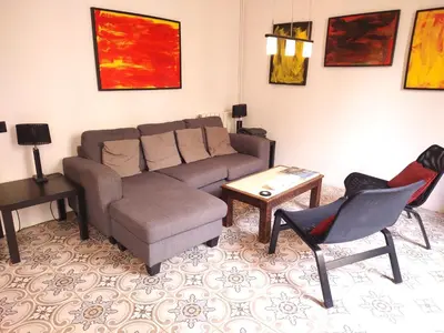 a living room with a couch and a table and chairs at Spacious aptmt close to Pl Universidad and Pl Catalunya, 2,5 bedrooms, balcony, heating, elevator Min 31 nights in Barcelona