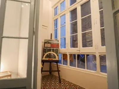 a room with windows and a stool in front at Spacious aptmt close to Pl Universidad and Pl Catalunya, 2,5 bedrooms, balcony, heating, elevator Min 31 nights in Barcelona