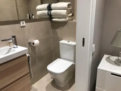a bathroom with a toilet and a sink and towels at Apartamento en Pedralbes in Barcelona