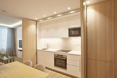 a kitchen with white cabinets and a table with chairs at Apartamento en Pedralbes in Barcelona