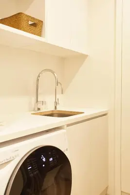 a white kitchen with a sink and a washing machine at Apartamento en Pedralbes in Barcelona