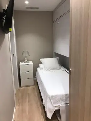 a small bedroom with a bed and a night stand at Apartamento en Pedralbes in Barcelona