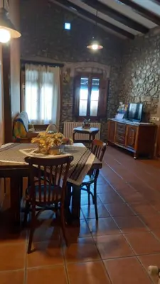 a dining room with tables and chairs and a tv at Can Bicicleta de Dalt in Olesa de Bonesvalls
