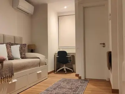a bedroom with a bed and a desk and a chair at Gran Vía de Carlos III B in Barcelona