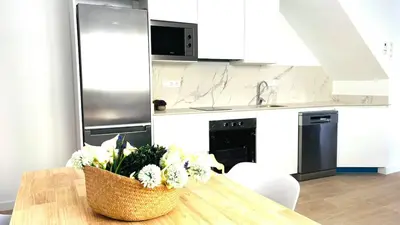 a kitchen with a table with a vase of flowers on it at Apartamento familiar by prestigi in Terrassa
