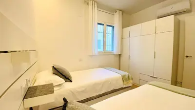 a small bedroom with two beds and a window at Apartamento familiar by prestigi in Terrassa