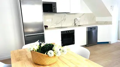 a kitchen with a table with a vase of flowers on it at Apartamento familiar by prestigi in Terrassa