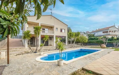 a swimming pool in front of a house at Cozy Home In Calafell With Wifi in Calafell