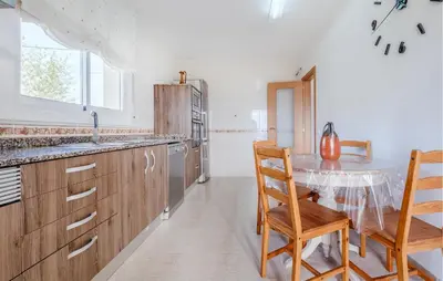 a kitchen with a table and chairs and a sink at Cozy Home In Calafell With Wifi in Calafell