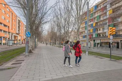 two women walking down a sidewalk in a city at Playa a pie y a 15 minutos de Ramblas y Plaza Catalunya en metro in Sant Adria de Besos