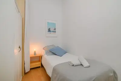 a bedroom with two beds and a table with a lamp at Playa a pie y a 15 minutos de Ramblas y Plaza Catalunya en metro in Sant Adria de Besos