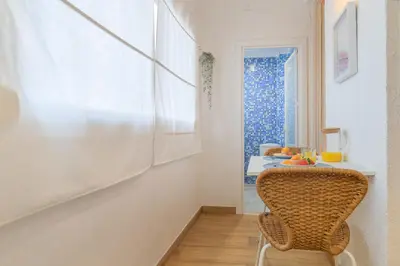 a room with a chair and a table and a window at Playa a pie y a 15 minutos de Ramblas y Plaza Catalunya en metro in Sant Adria de Besos