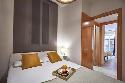a bedroom with a bed with a tray of food on it at BBarcelona Mallorca Flats in Barcelona
