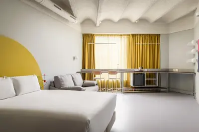 a hotel room with a bed and a living room at BYPILLOW Flamant in Barcelona