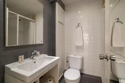 a bathroom with a sink and a toilet and a mirror at Stay U-nique Apartment Creu Coberta in Barcelona