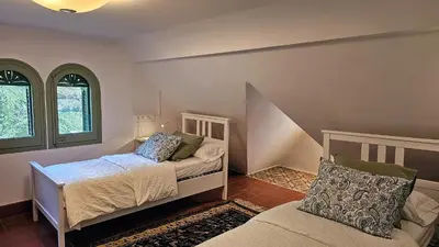a bedroom with two beds and a couch at Can Puig Barata, Aiguafreda in Aiguafreda