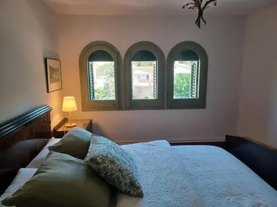 a bedroom with three windows and a bed at Can Puig Barata, Aiguafreda in Aiguafreda