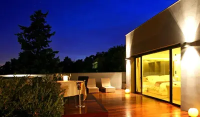 a house with a balcony with a bed and a table at ABaC H&R Barcelona Monument in Barcelona
