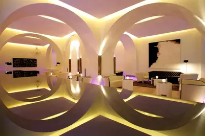 a living room with white chairs and a room with a painting at ABaC H&R Barcelona Monument in Barcelona
