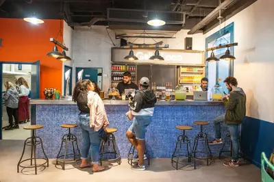 a group of people standing at a bar at Safestay Barcelona Passeig de Gràcia in Barcelona