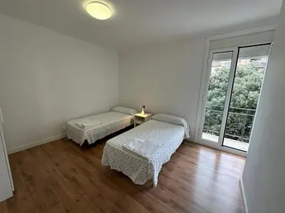 a white room with two beds and a window at Esglesia 2 in Arenys de Mar