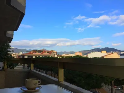 a cup of coffee sitting on a table on a balcony at Perfect Apartment near the beach and Barcelona in Pineda de Mar