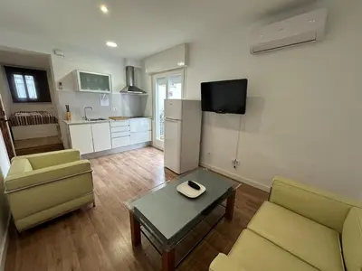 a living room with a couch and a table and a kitchen at L'Esglesia 3 in Arenys de Mar