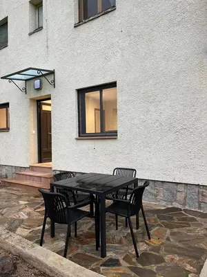 a black table and chairs in front of a building at Can Sura in Campíns