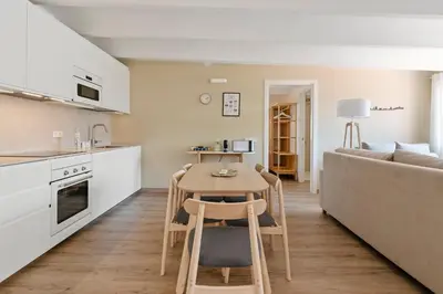 a kitchen and living room with a table and a couch at Flateli Pelayo H7 in Barcelona