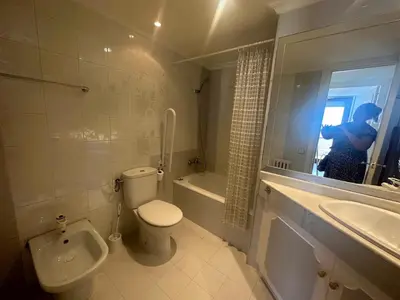 a woman taking a picture of a bathroom with a toilet and sink at Can Xifre 1 in Arenys de Mar