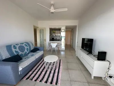 a living room with a blue couch and a tv at Can Xifre 1 in Arenys de Mar