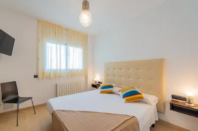 a bedroom with a large bed with two pillows at InSitges Center in Sitges