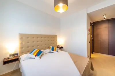 a bedroom with a large white bed with two pillows at InSitges Center in Sitges