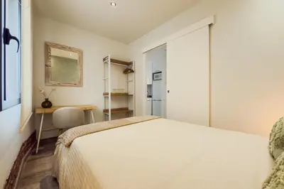 a bedroom with a bed and a desk and a table at Novus Homes Barcelona Plaza España in Barcelona