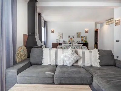 a living room with a gray couch and a table at Ollie Apartment by Hello Homes Sitges in Sitges