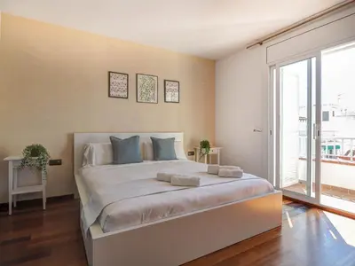 a large bed in a room with a large window at Ollie Apartment by Hello Homes Sitges in Sitges