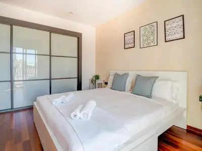 a bedroom with a large white bed with slippers on it at Ollie Apartment by Hello Homes Sitges in Sitges