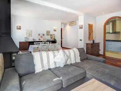 a living room with a couch and a kitchen at Ollie Apartment by Hello Homes Sitges in Sitges