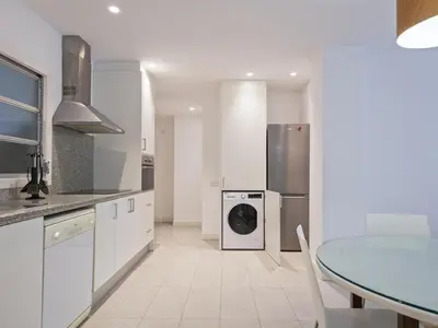 a kitchen with a washing machine and a table at Winahost Barcelona Pedralbes in Barcelona