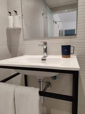 a bathroom with a white sink and a mirror at Hotel Calella by Beatriz Hoteles in Calella