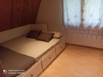 a small bedroom with two beds and a window at Villa cascada in Sant Cebrià de Vallalta