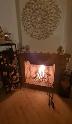 a fireplace in a living room with a fire at Villa cascada in Sant Cebrià de Vallalta