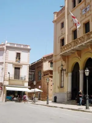 a building with a flag on the side of a street at Pis Sitges centre in Sitges