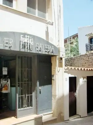 a store with a sign on the side of a building at Pis Sitges centre in Sitges