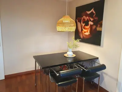 a dining room table with black chairs and a lamp at Modern apartment in Diagonal Mar in Barcelona